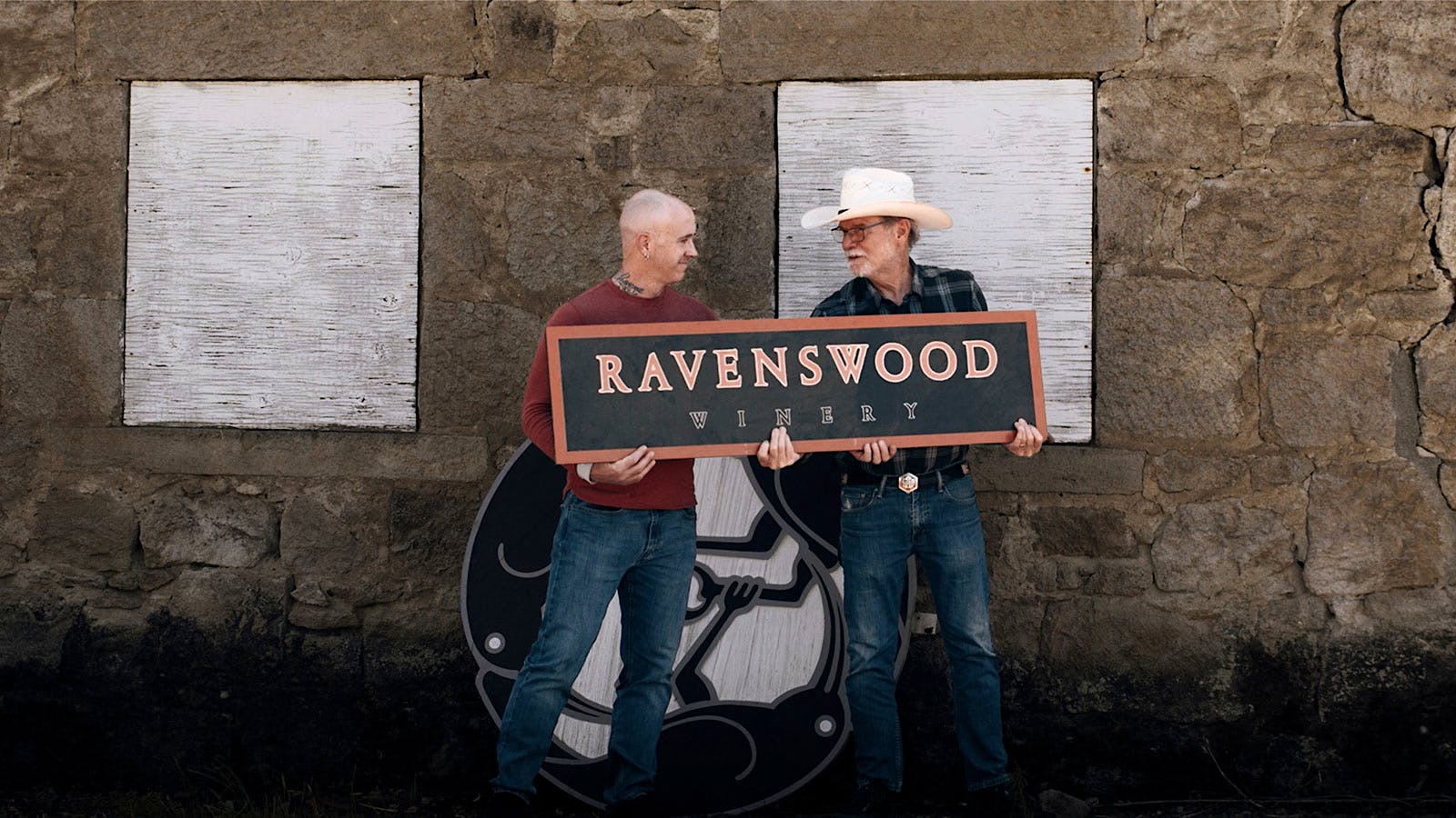 Winemakers Michael Eddy-Cort and Joel Peterson hold a Ravenswood sign.