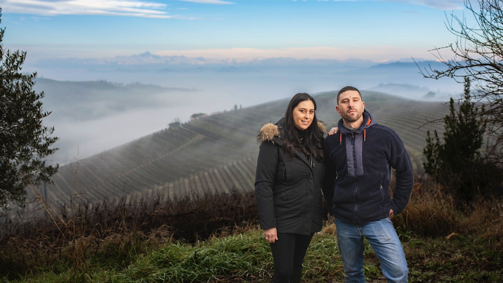 Luisa and Francesco Rocca stand together in one of Bruno Rocca's vineyards overlooking the hills of Barbaresco in Piedmont, Italy.